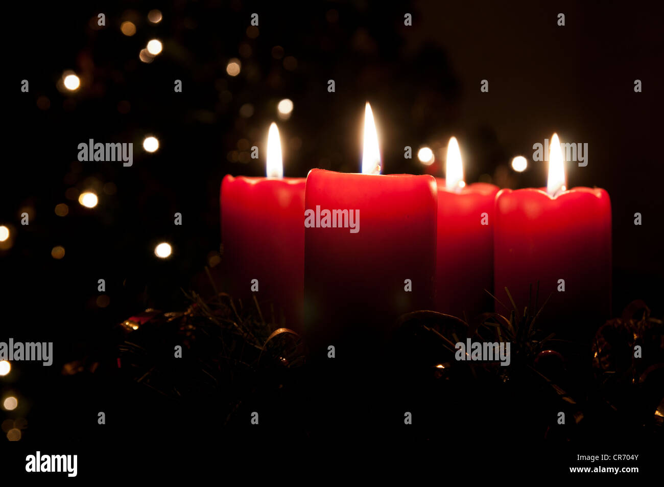 Natale corona di Avvento con red candele accese. Luci su X-mas tree in background Foto Stock