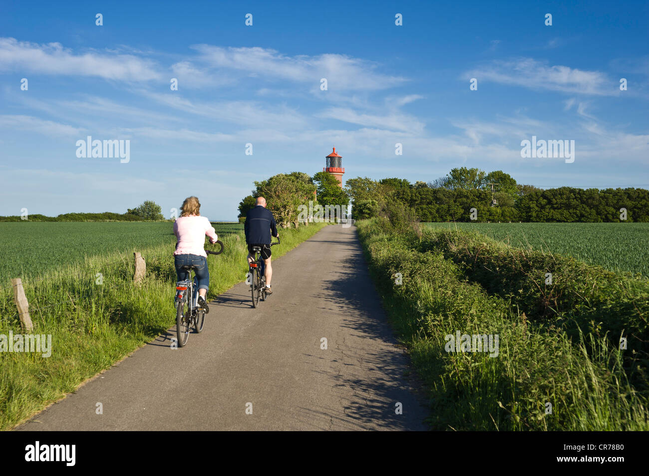 I ciclisti nella parte anteriore del faro sulle rupi costiere di Staberhuk, Fehmarn Island, Mar Baltico, Schleswig-Holstein Foto Stock