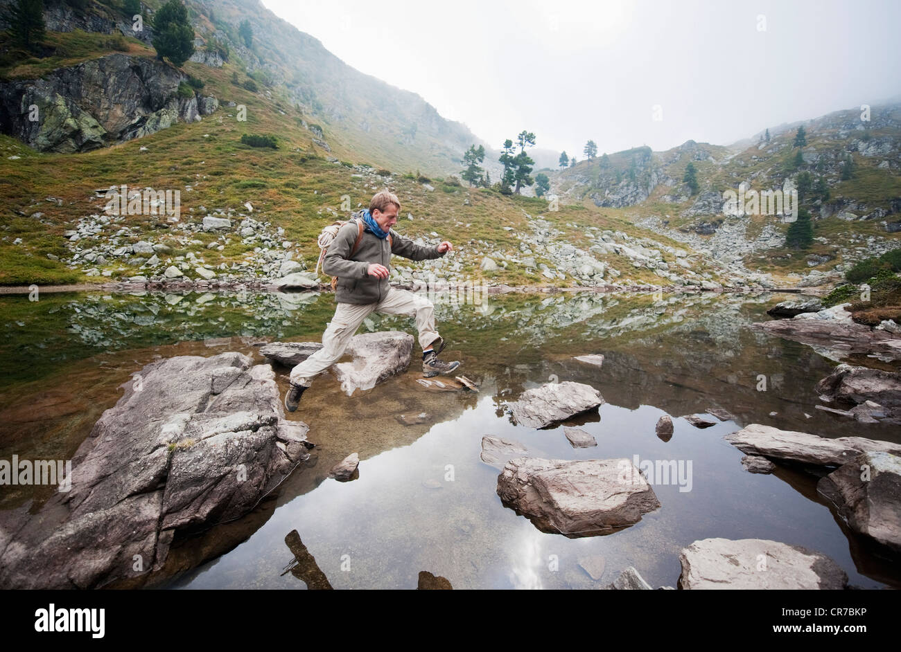 L'Austria, la Stiria, metà uomo adulto saltando al Lago Spiegelsee Foto Stock