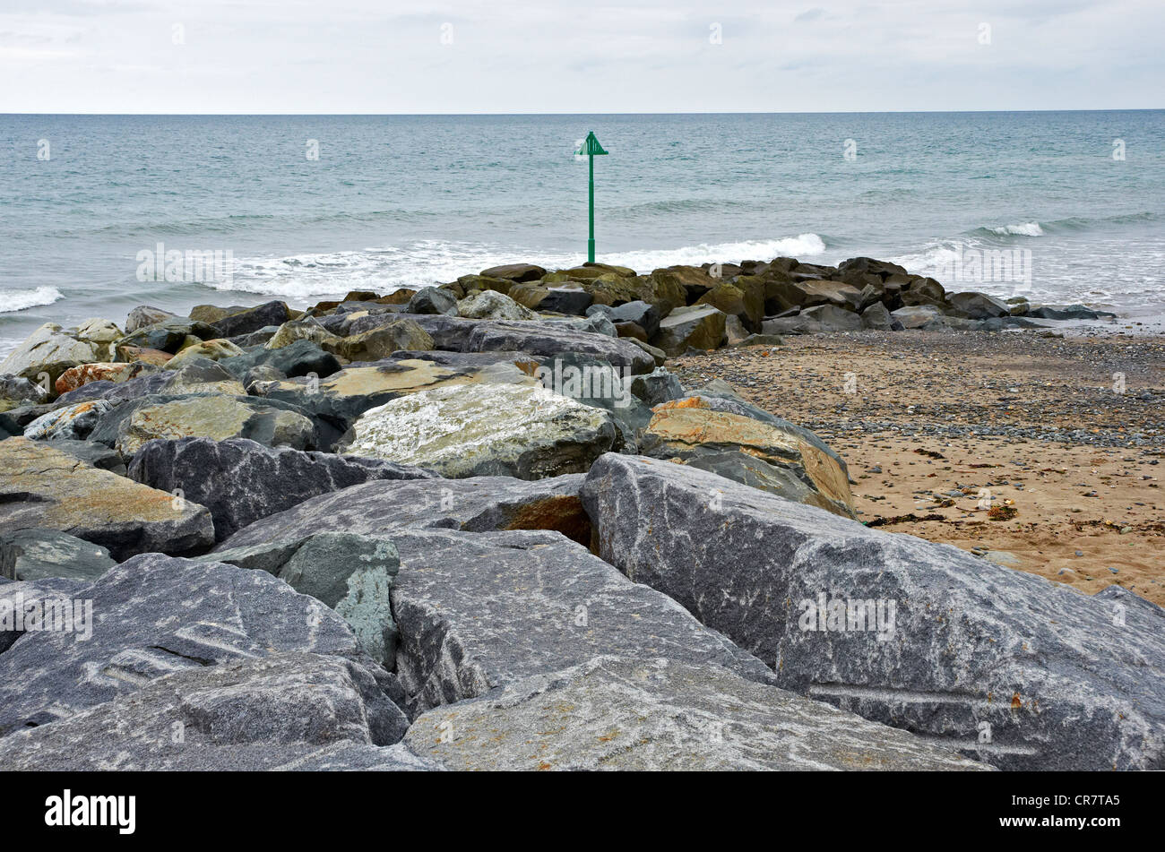 Grande roccia corazza groyne parte del recente difese del mare a nord della spiaggia di Tywyn Foto Stock