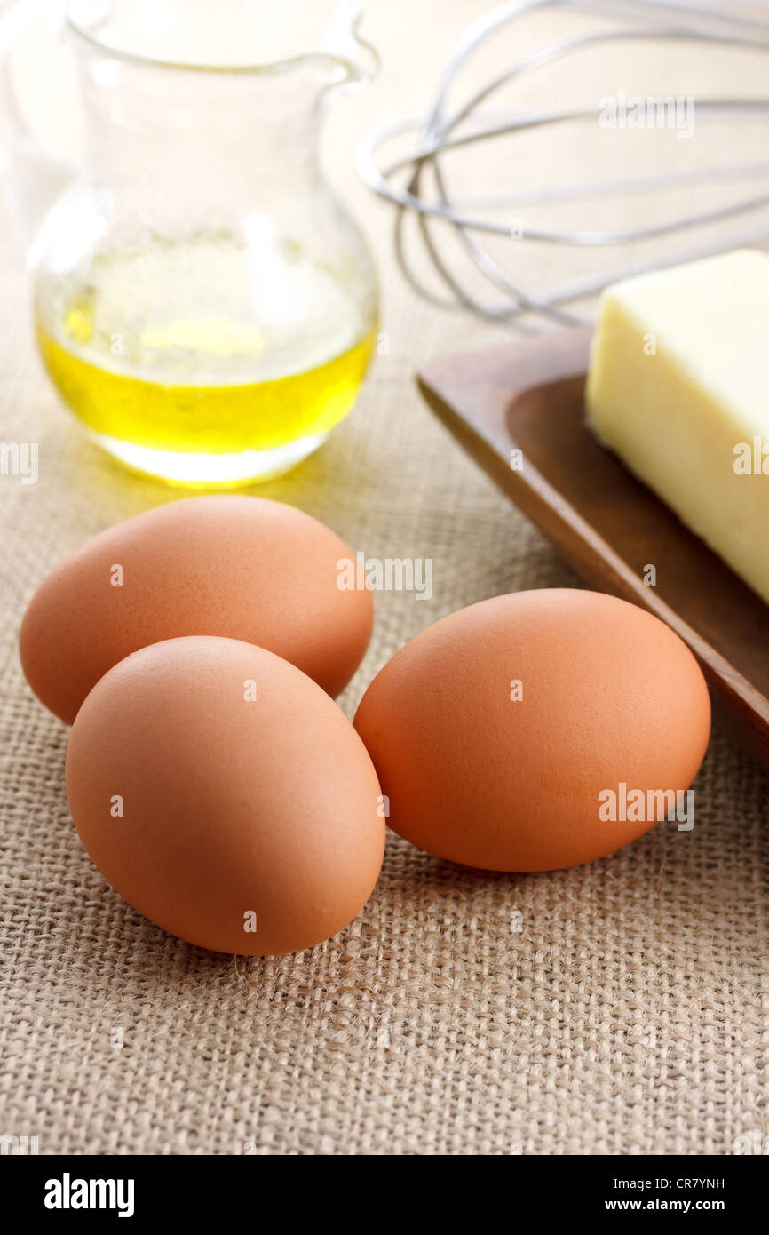 Uova con olio e burro mescolando con una frusta Foto Stock