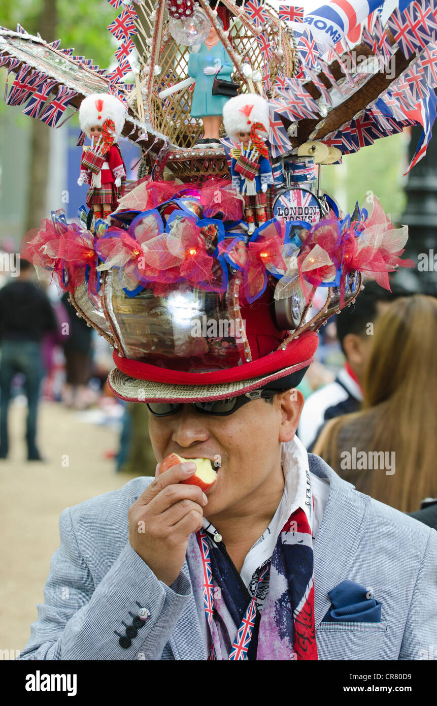 Uomo con cappello patriottico mangia apple il diamante della regina celebrazioni giubilari una Reveler attesa per concerto pop The Mall 4/6/12 Foto Stock