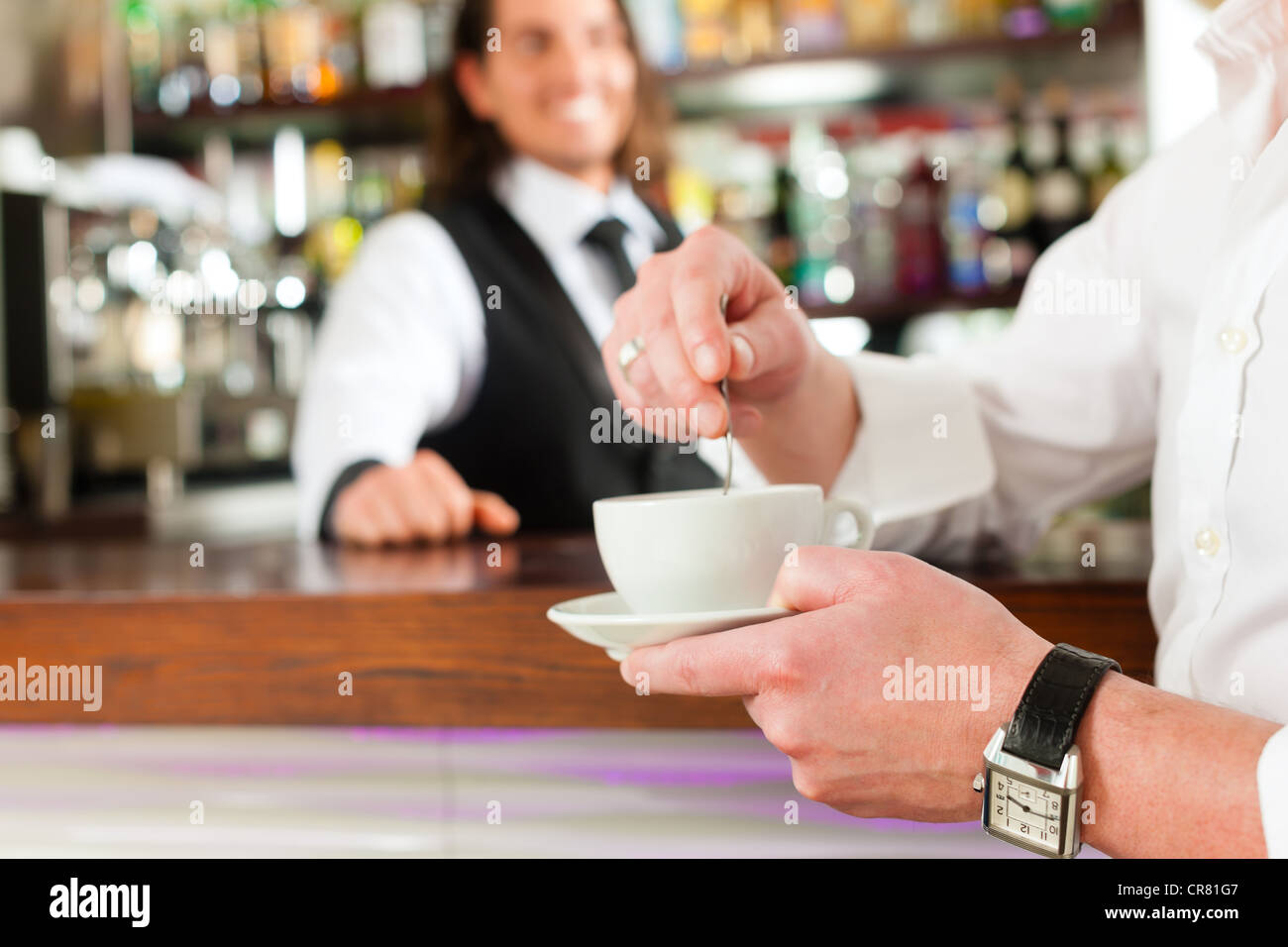 Coffee shop - barista in cafe con un client, egli è di bere il caffè Foto Stock