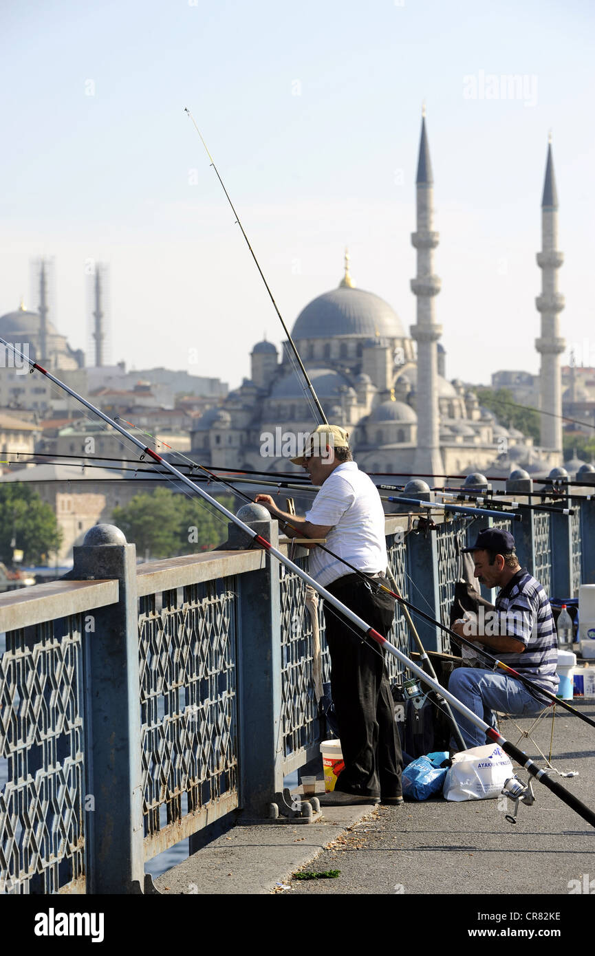 I pescatori sul Ponte di Galata, Koepruesue Galata Bridge e la Yeni Cami, Nuova Moschea, Istanbul, Turchia Foto Stock