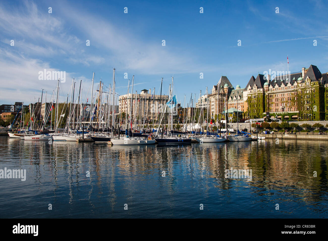 Marina piena di barche a vela in un tranquillo porto azzurro di fronte all'Empress hotel in Victoria, British Columbia, Canada Foto Stock