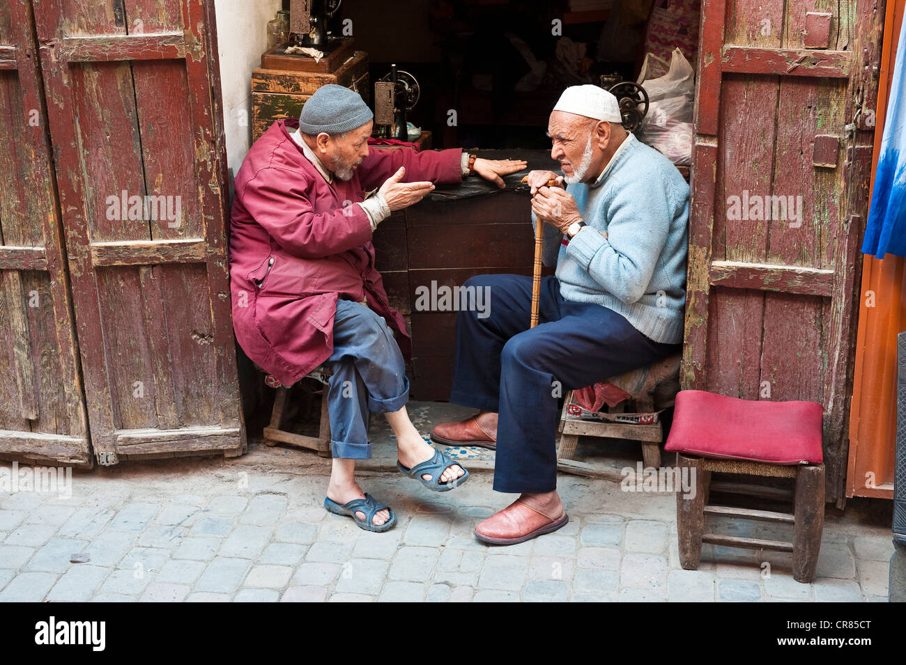 Marocco Alto Atlante Marrakech città imperiale medina elencati come patrimonio mondiale dall' UNESCO vecchio conversando marocchino in un negozio di sartoria Foto Stock