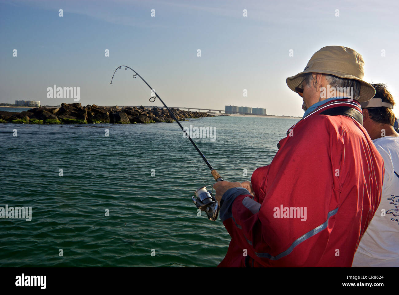Lo sport maschile pescatore la riproduzione di pesci ingresso Perdido Pass frangiflutti la pesca costiera Foto Stock