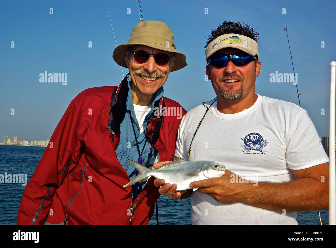 Sport guida di pesca tenendo pompano acqua salata costiera pesci gioco  maschio pescatore Perdido Pass Foto stock - Alamy