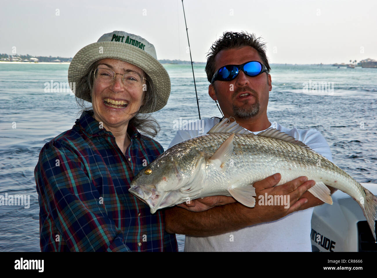 Donna sorridente sport il pescatore con la sua fascia costiera di sebaste saltwater game pesce che guida di pesca è azienda Perdido Pass Foto Stock