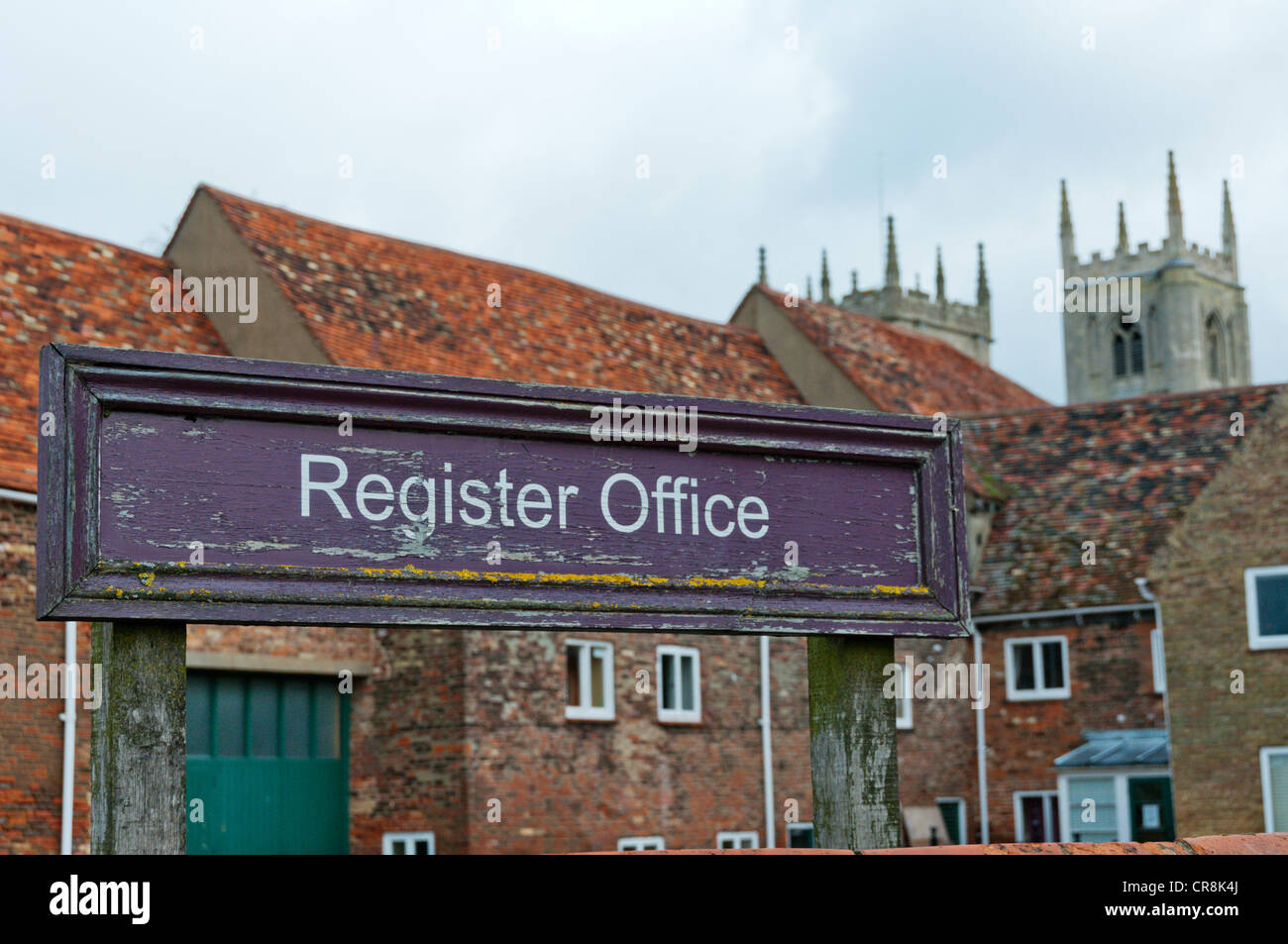 Per firmare il registro ufficio a King's Lynn, Norfolk con le torri della chiesa di St Margaret in background. Foto Stock