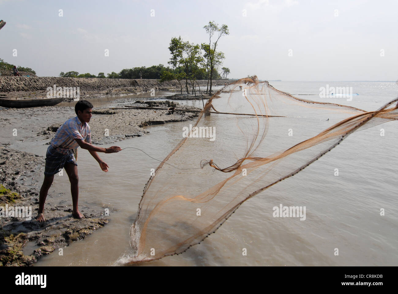 Bangladesh , villaggio Kalabogi presso il river Shibsha vicino alla baia del Bengala, i popoli sono i più colpiti dai cambiamenti climatici, pescatore getta la rete Foto Stock