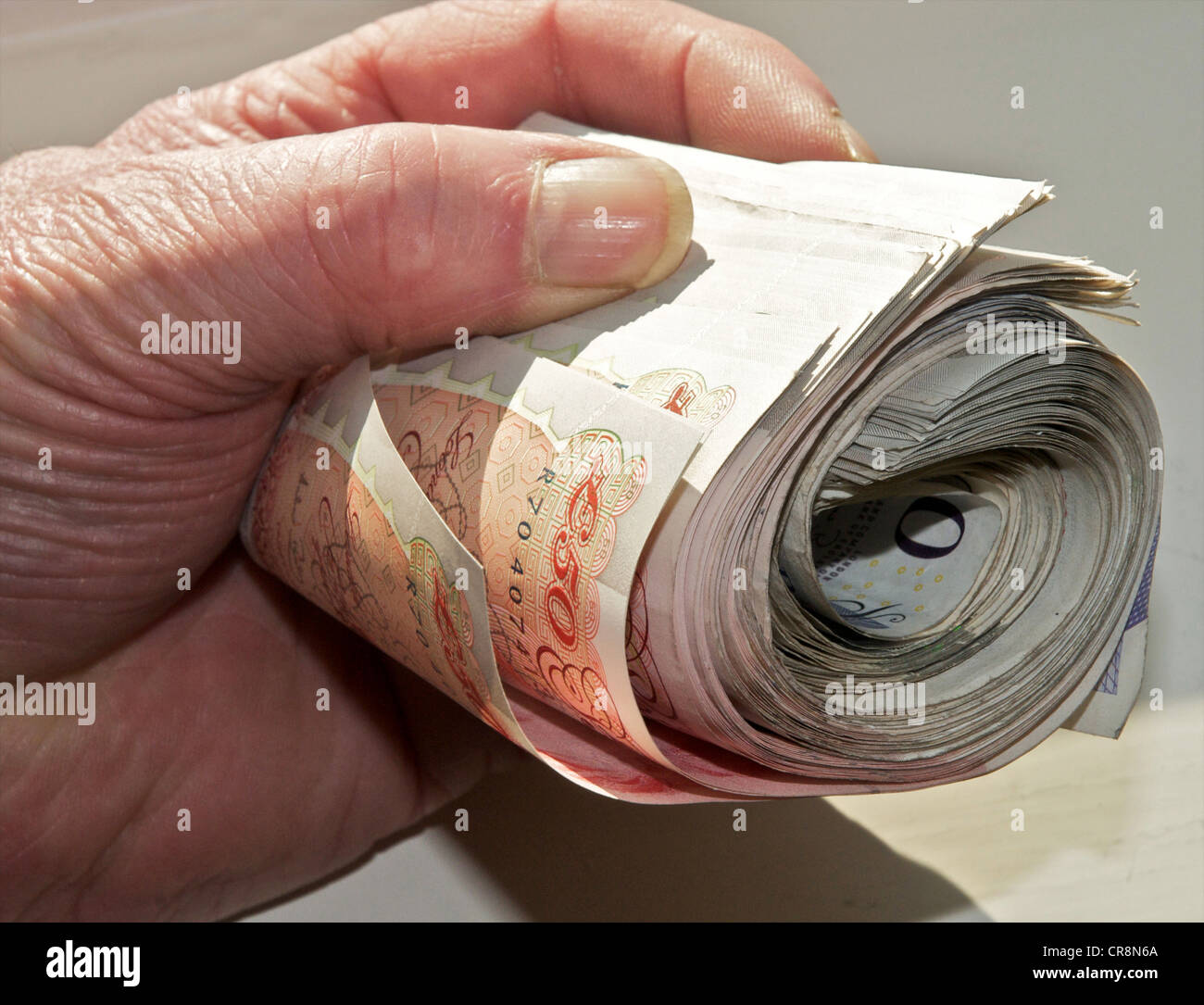 Contanti in mano - bundle di sterling note tenuto in una mano il denaro NEL REGNO UNITO Foto Stock