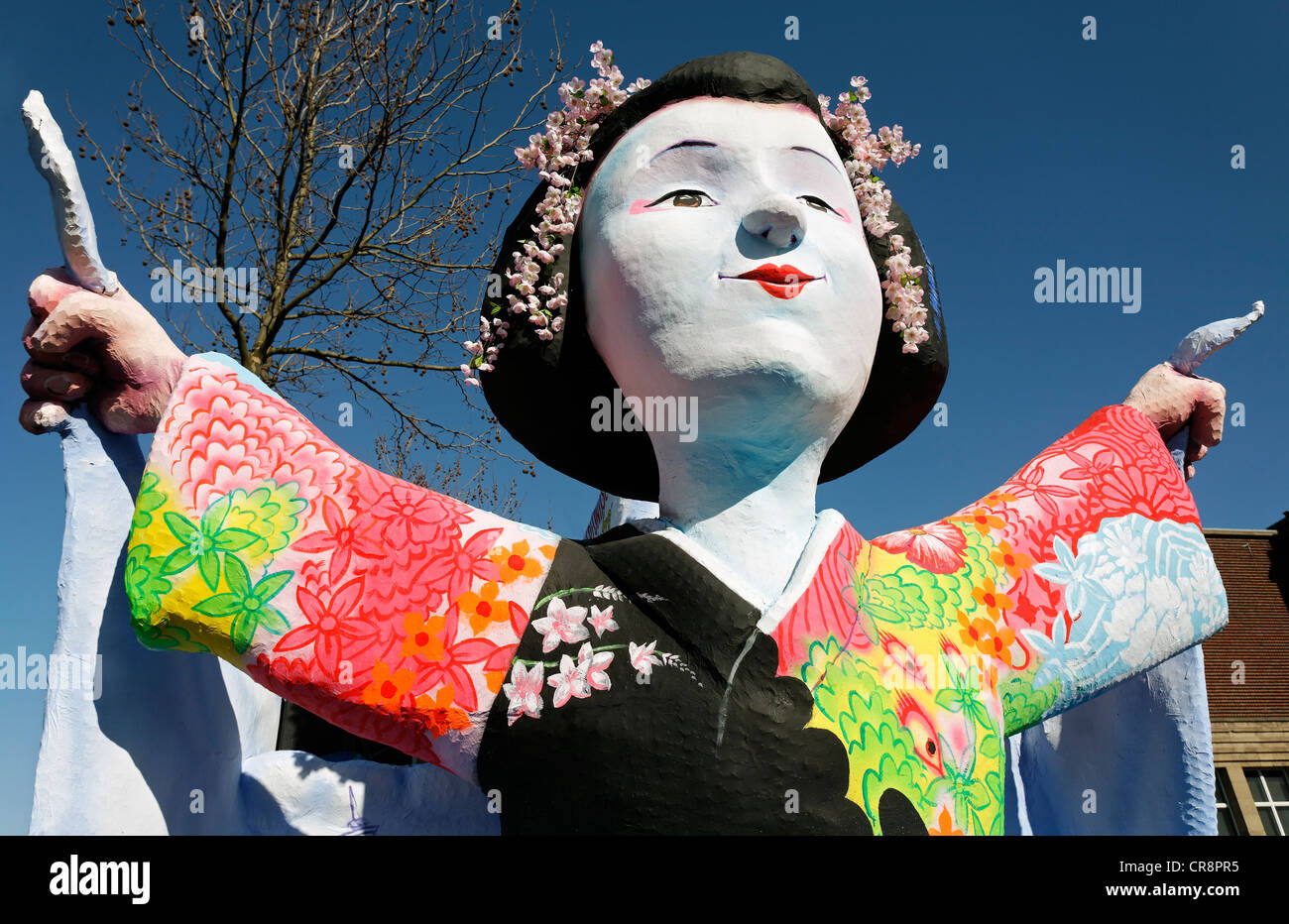 Donna Giapponese che indossa un kimono con le braccia tese, carta-mache figura, sfilata galleggiante al Rosenmontagszug sfilata di Carnevale Foto Stock