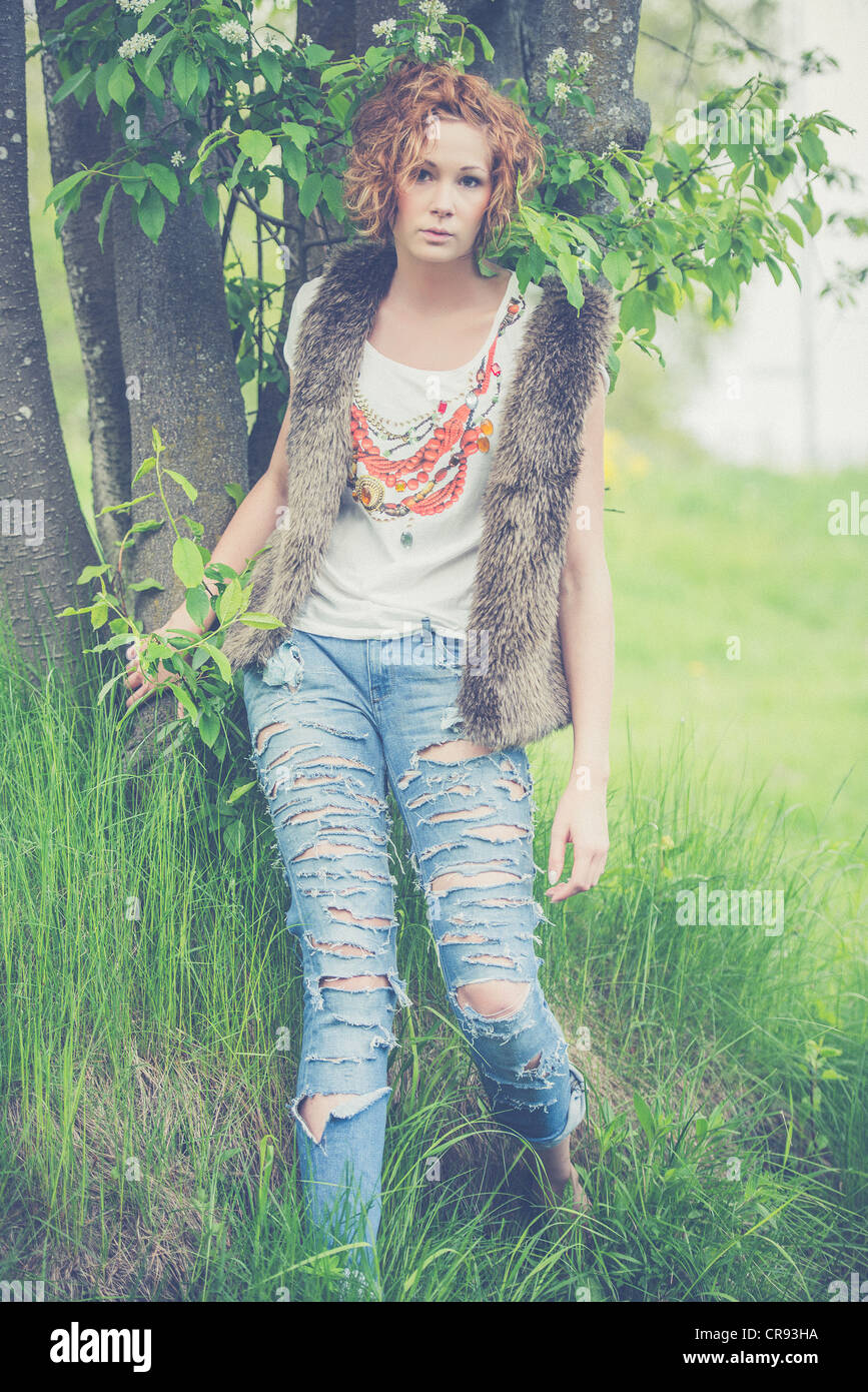 Una giovane bruna in una impostazione di estate Foto Stock
