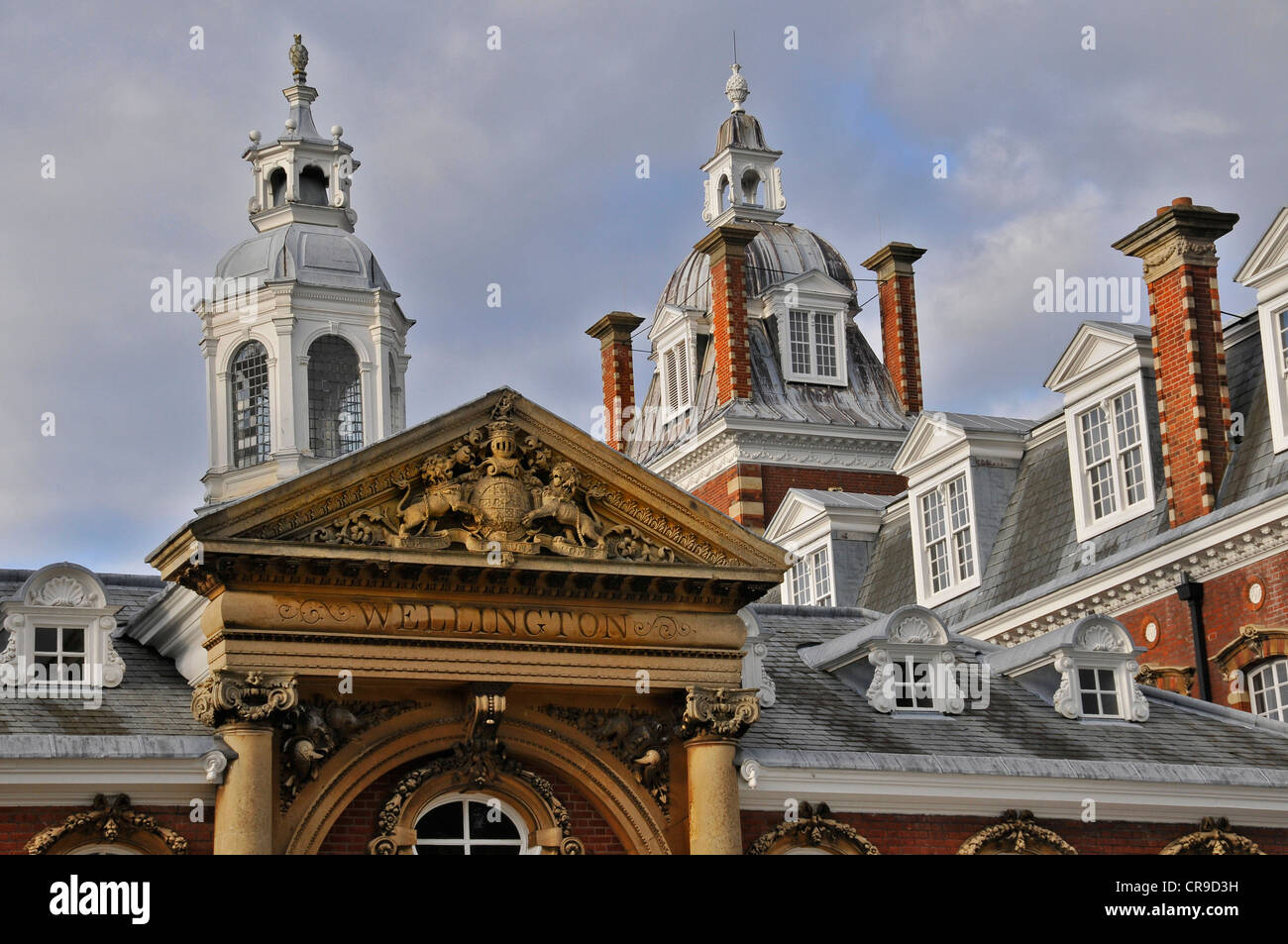 Parte posteriore del Wellington College Berkshire, guglie contro grandi cieli,mostra la scuola moto su pietra scolpita gable.Mostra torre campanaria e vincere Foto Stock