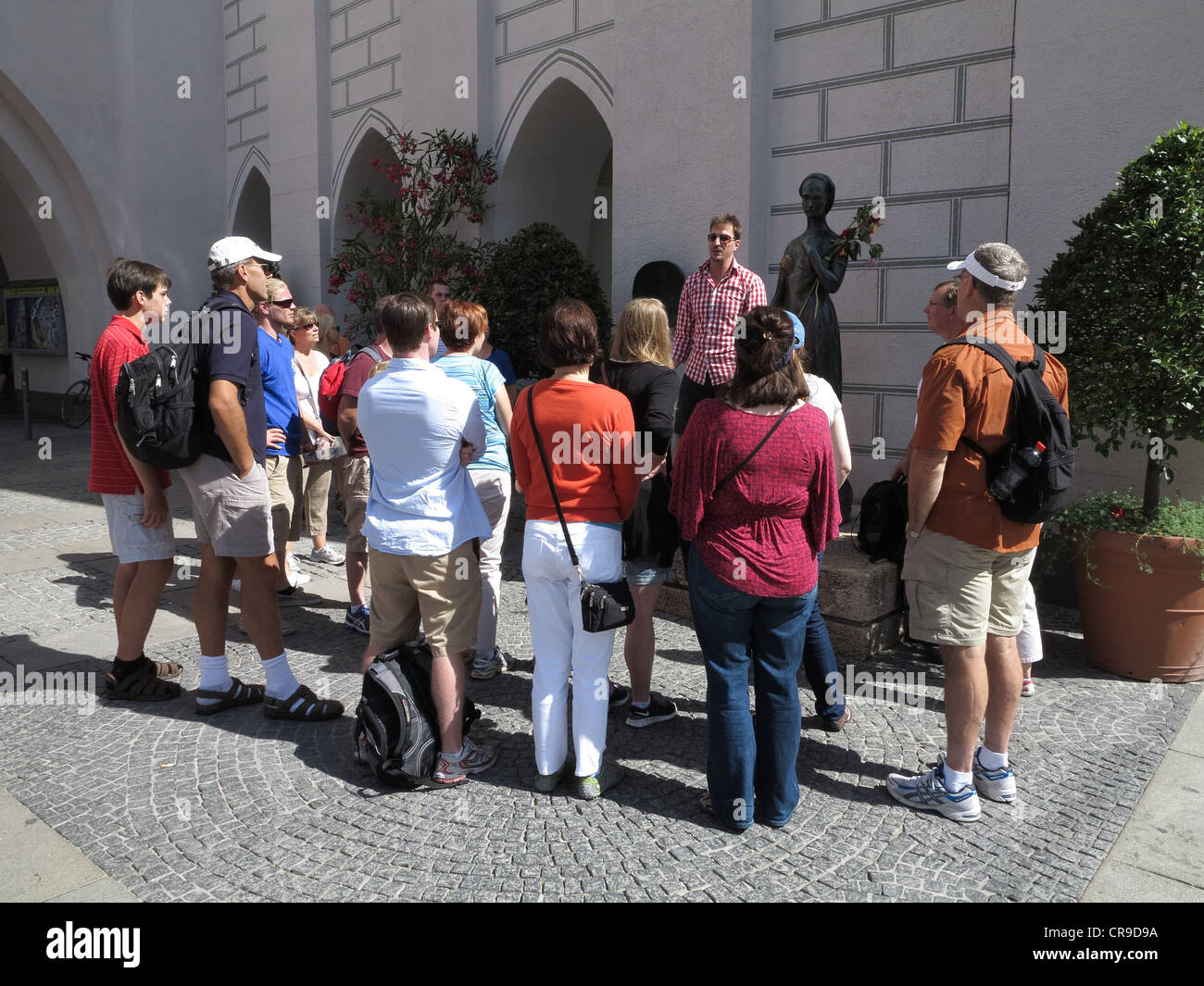 Germania Monaco di Baviera Marienplatz gruppo di tour. Leader dando informazioni per i turisti al di fuori del Museo del Giocattolo Foto Stock