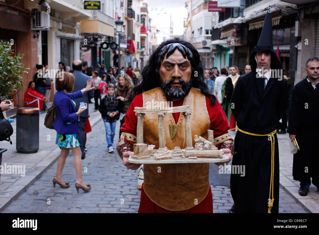 Un uomo mascherato vestito come un personaggio biblico custodisce una reliquia durante una PASQUA SETTIMANA SANTA PROCESSIONE in Puente Genil, Spagna Foto Stock