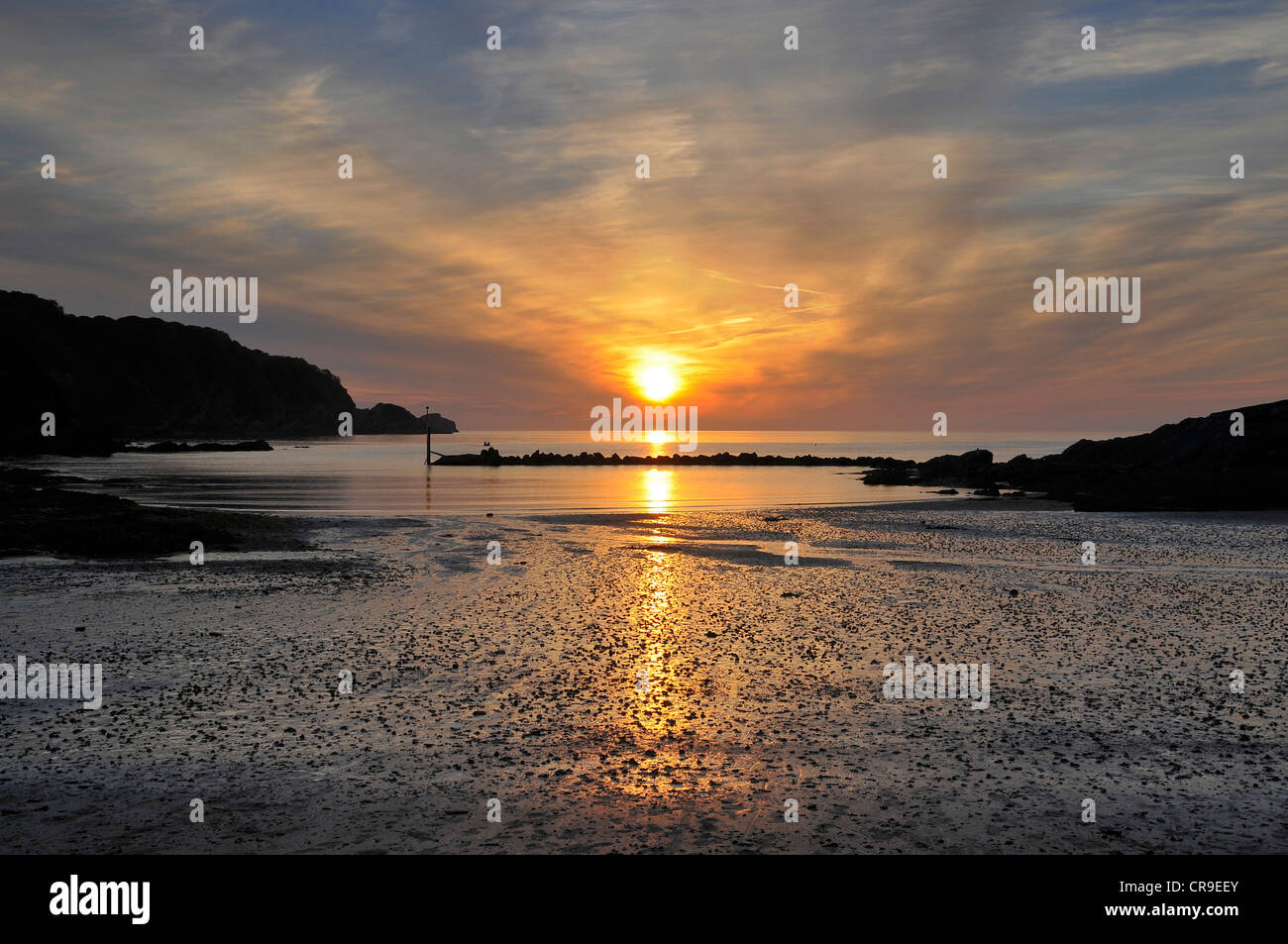 I pescatori di atterraggio su faggio nella Combe Martin, Devon, stagliano arancio luminoso Cielo di tramonto. Foto Stock