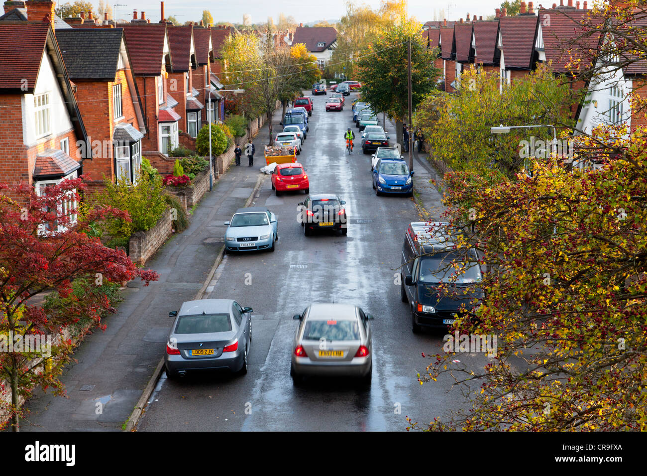 Suburban street. Guardando verso il basso in corrispondenza di alloggiamento e del traffico su una strada residenziale di automobili parcheggiate, West Bridgford, Nottinghamshire, England, Regno Unito Foto Stock