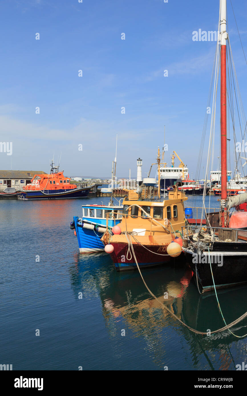 Barche da pesca ormeggiate nel porto interno con la scialuppa di salvataggio oltre a Kirkwall, isole Orcadi Scozia, Regno Unito, Gran Bretagna Foto Stock