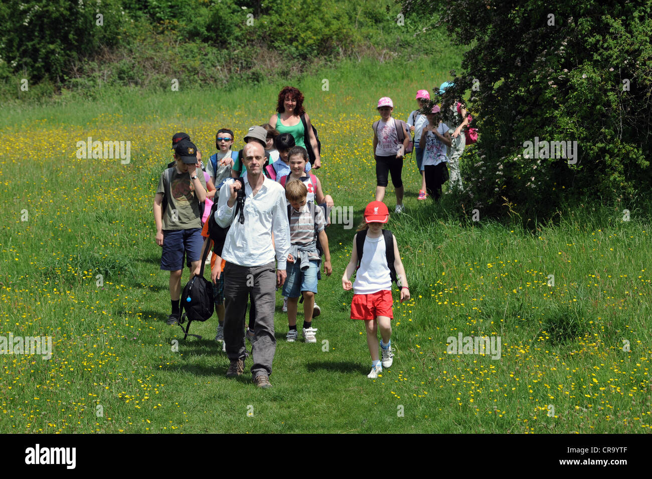 Insegnante di scuola di leader i bambini ad una natura a piedi lungo il Lodge in campo Ironbridge Shropshire Foto Stock