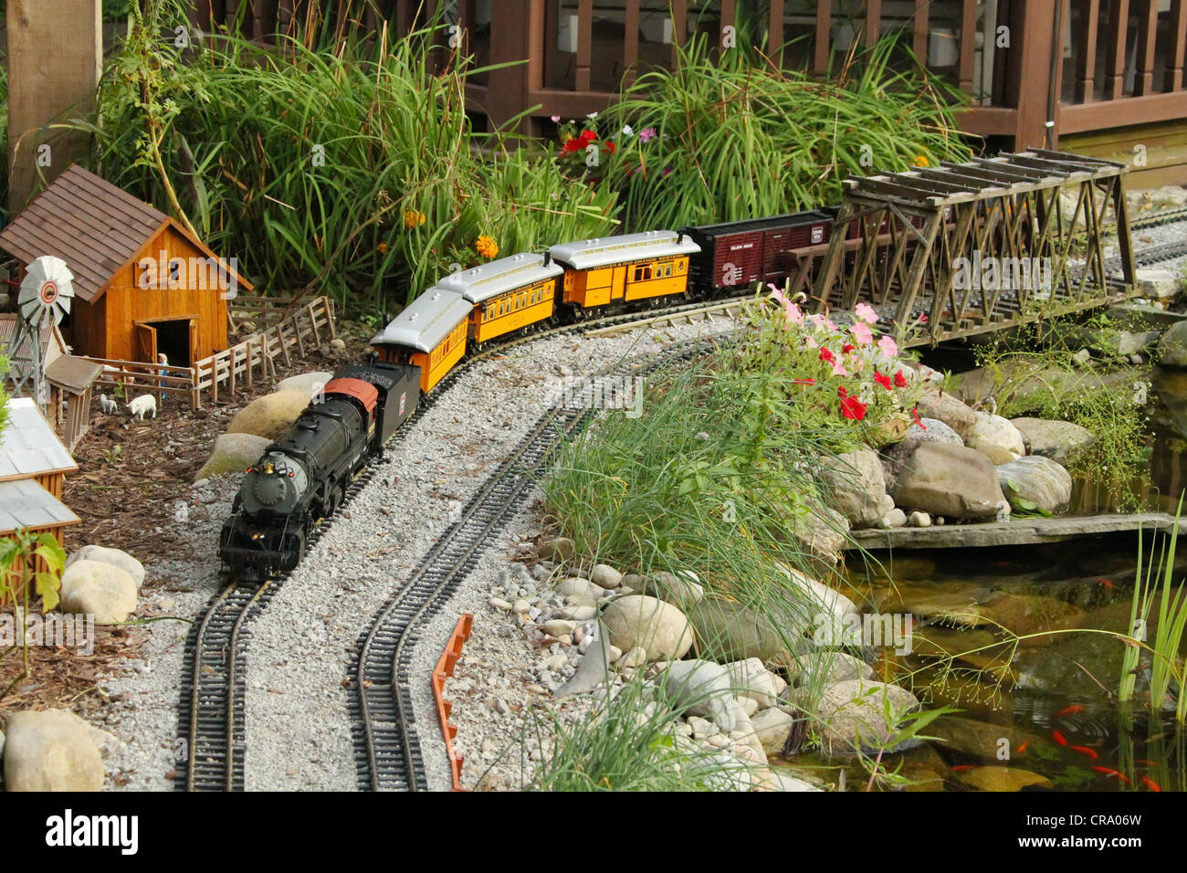 Un giardino di modello di treno viaggia tra la fattoria e il lago. Foto Stock