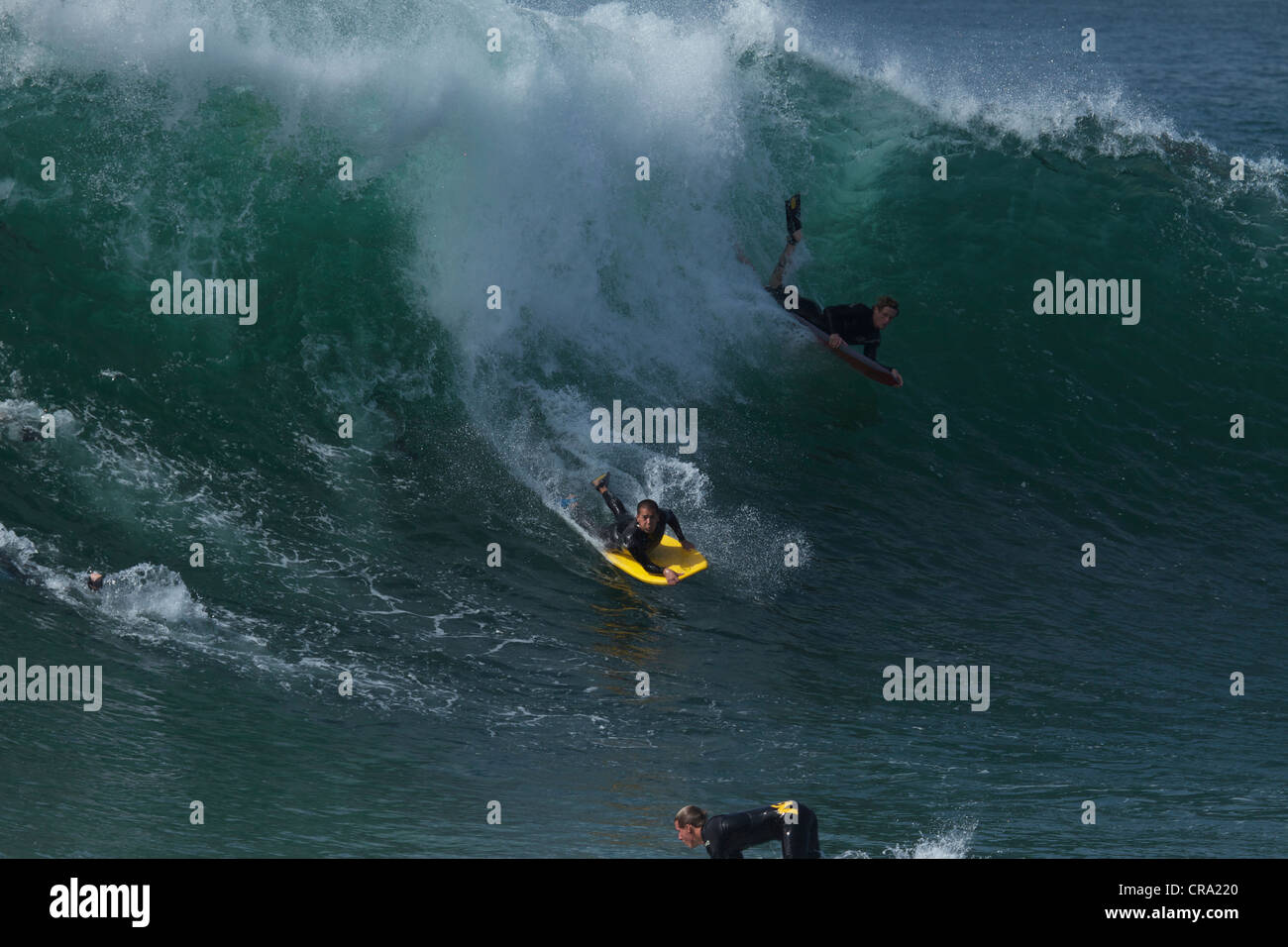 Bodyboarder a cavallo di un enorme ondata a cuneo di Newport Beach in California Foto Stock