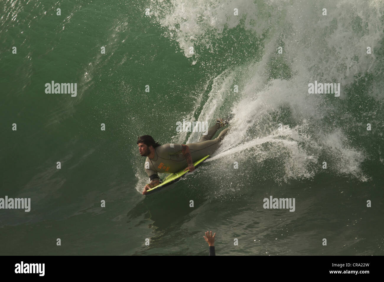 Bodyboarder a cavallo di un enorme ondata a cuneo di Newport Beach in California Foto Stock