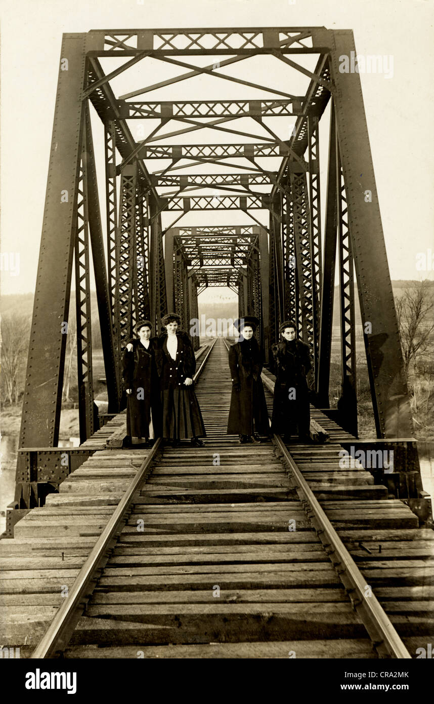 Le quattro ragazze passeggiando sui binari della ferrovia sul ponte Foto Stock