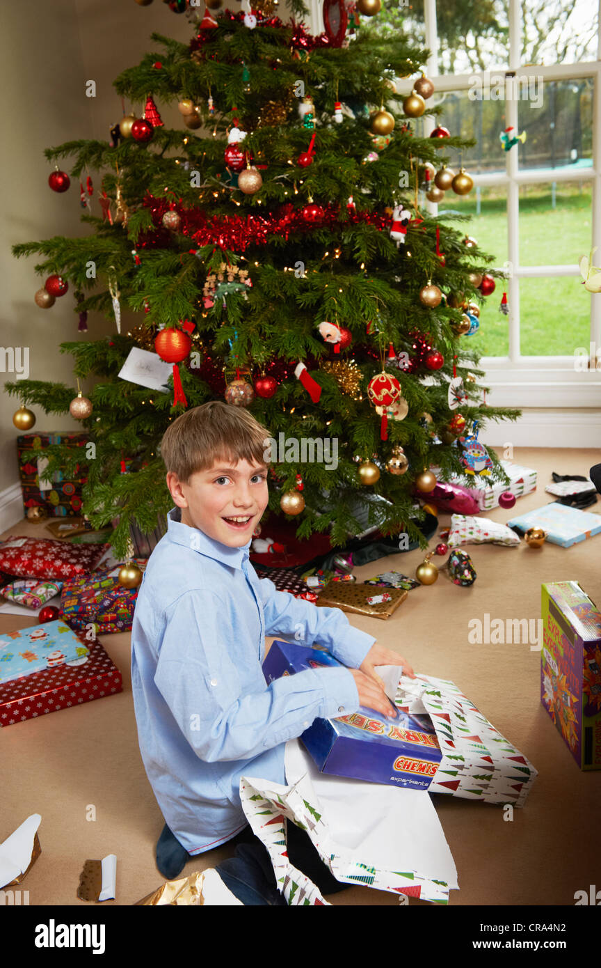 Ragazzo sorridente apertura regalo di Natale Foto Stock
