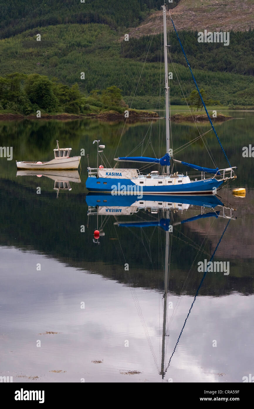Le barche si riflette nelle calme acque del Loch Leven, Scozia. Foto Stock
