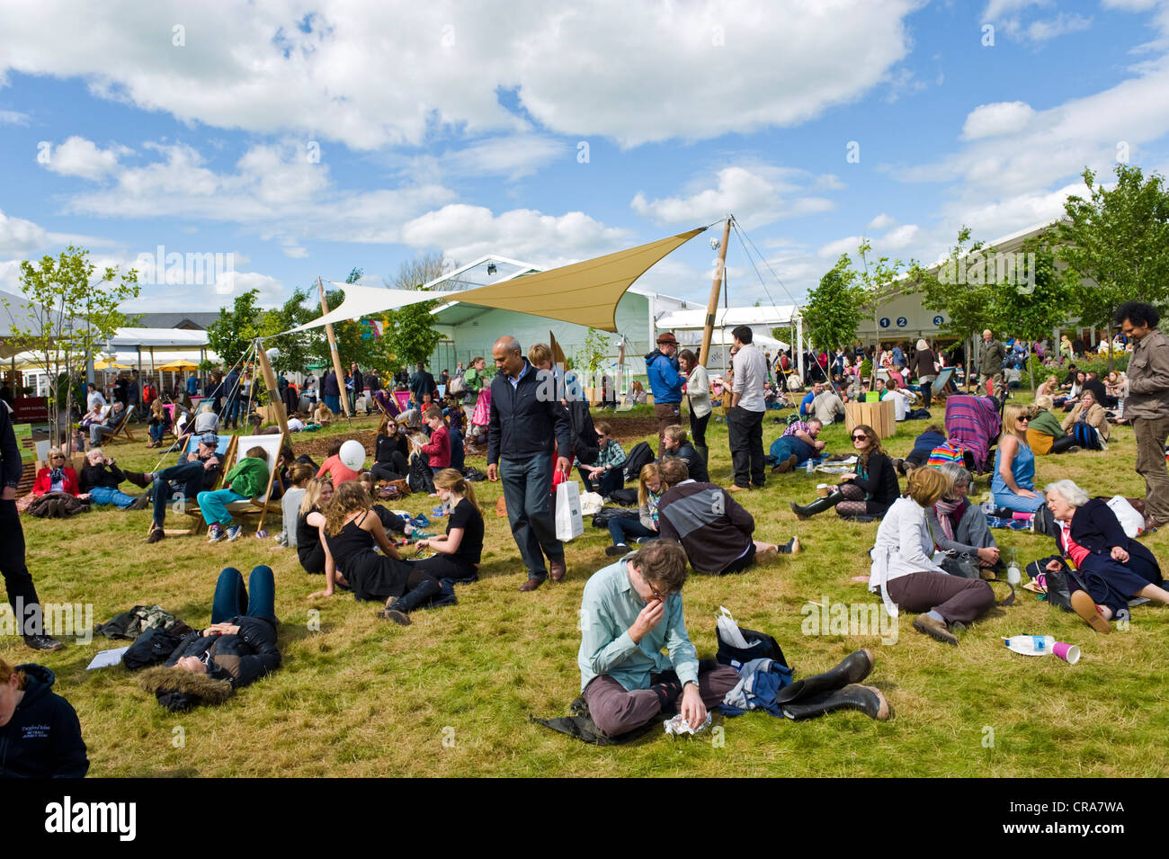 Visitatori godendo il sole sul prato presso il Telegraph Hay Festival 2012, Hay-on-Wye, Powys, Wales, Regno Unito Foto Stock