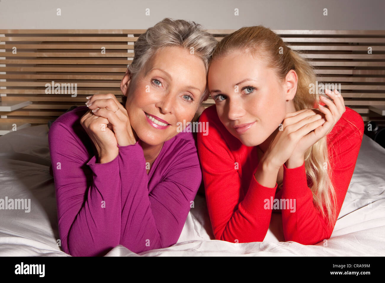 Madre e figlia la posa sul letto Foto Stock