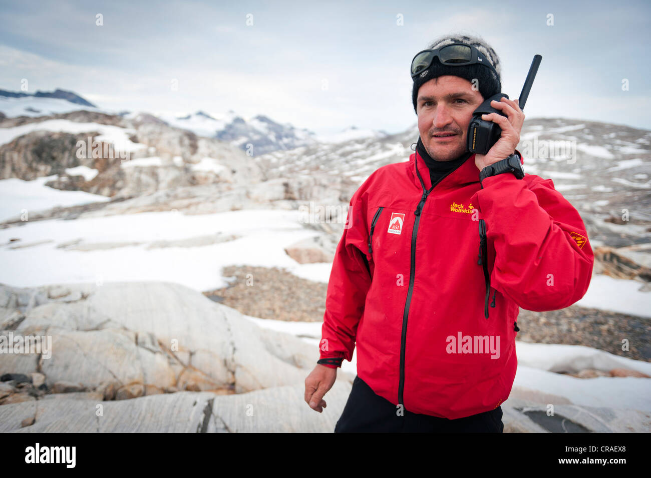Leader di un gruppo di escursionisti utilizzando un telefono satellitare, al Ghiacciaio Mittivakkat, Ammassalik Penisola, est della Groenlandia, Groenlandia Foto Stock