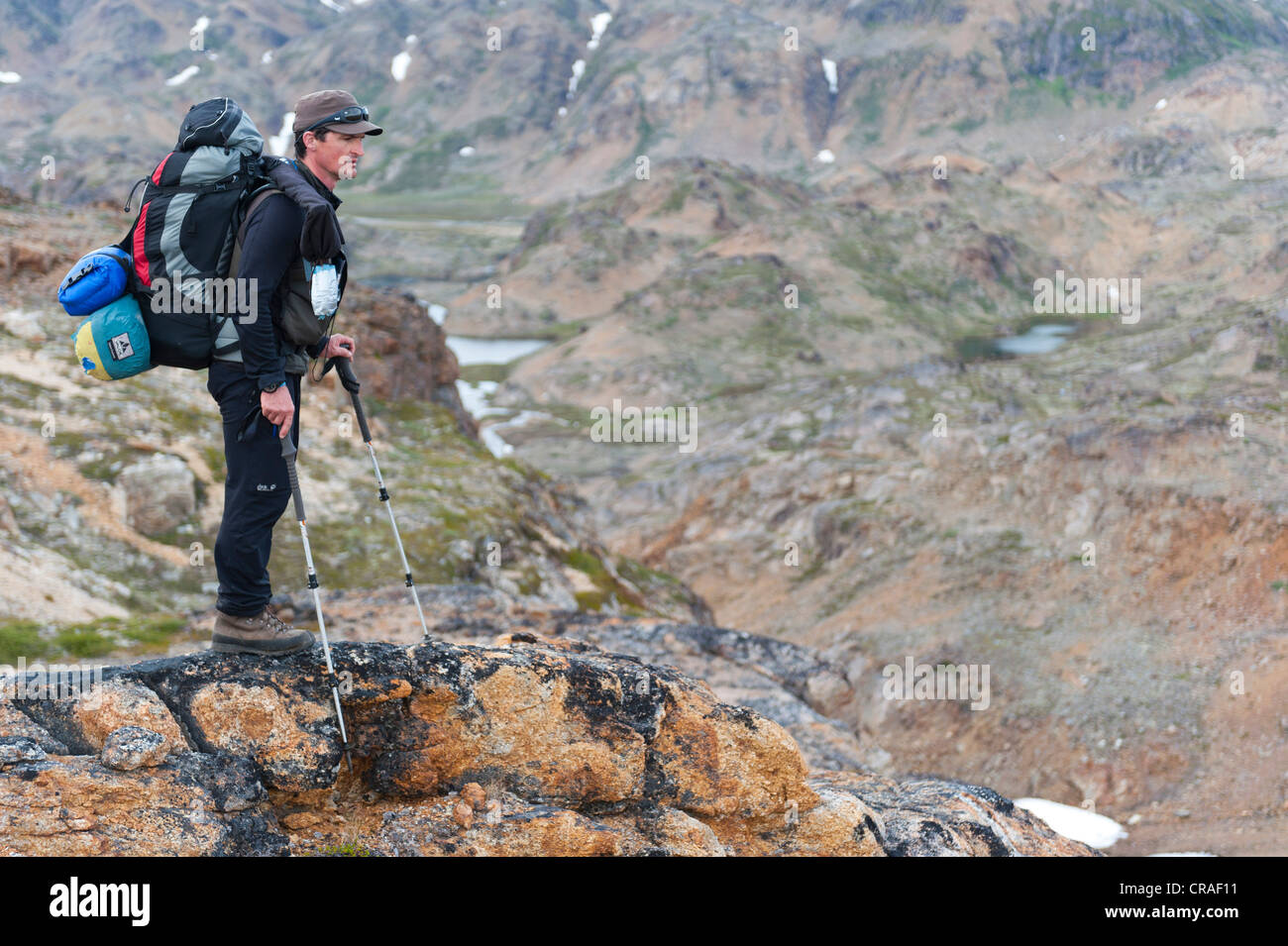 Leader di un gruppo di escursionisti con uno zaino e un fucile, Ammassalik Penisola, est della Groenlandia, Groenlandia Foto Stock