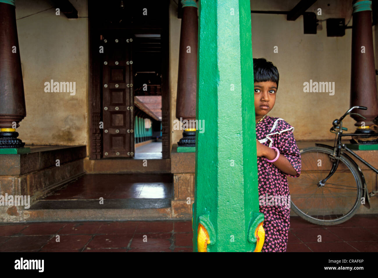 Bambina che si nasconde dietro il verde di un pilastro, vecchia magione, Chettinad, Tamil Nadu, India meridionale, India Foto Stock