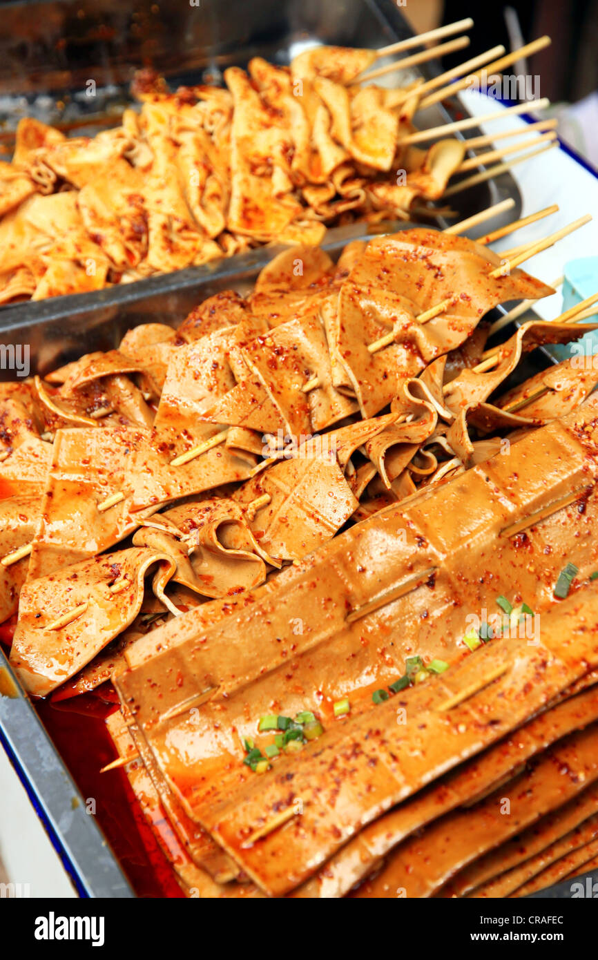 Un supporto di vendita gli spiedini di tofu a Chongqing Foto Stock