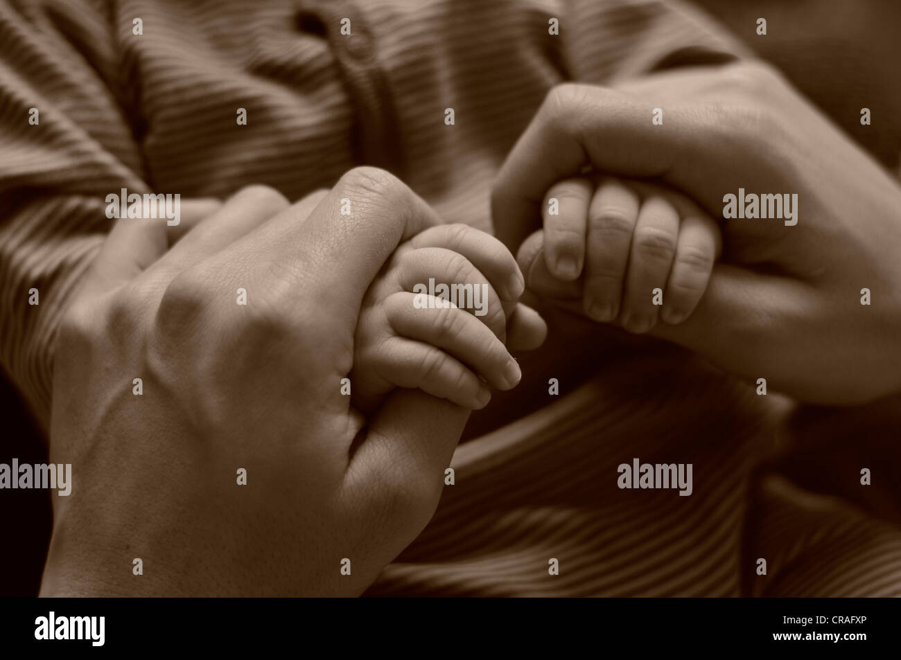 Parental mani tenendo le mani di un bambino Foto Stock