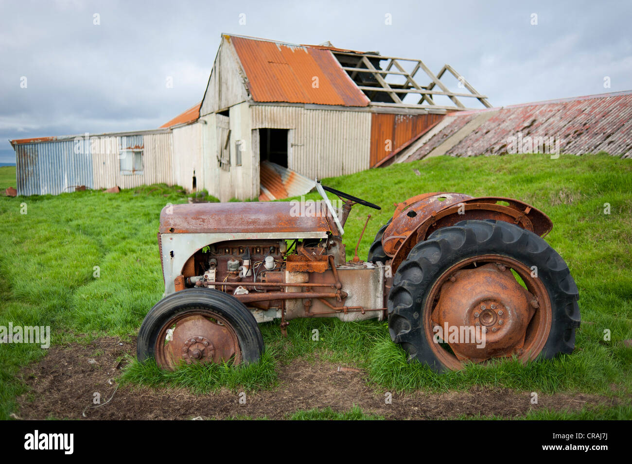 Esodo rurale, vecchio trattore di fronte all azienda abbandonata, vicino Kirkjubaejarklaustur, Kirkjubaejarklaustur, Skaftárhreppur, Suðurland Foto Stock