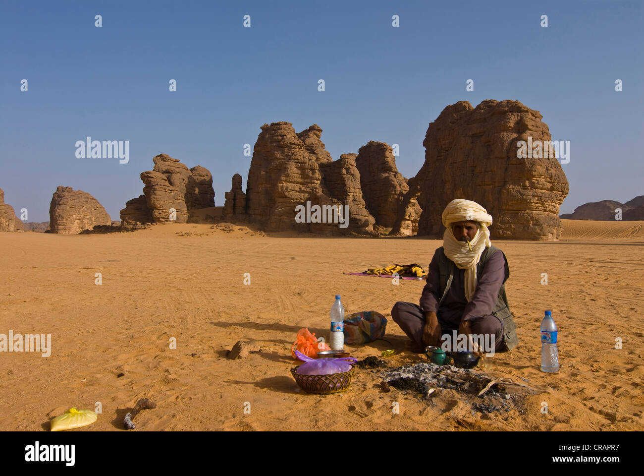 Uomo nativo prendendo una pausa nel deserto, Tikoubaouine, Algeria, Africa Foto Stock