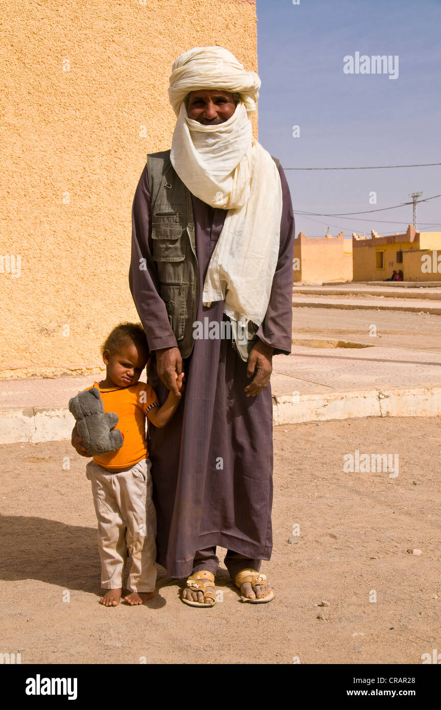 Bambino in piedi accanto al padre, Tadrat, Tasset, Algeria, Africa Foto Stock