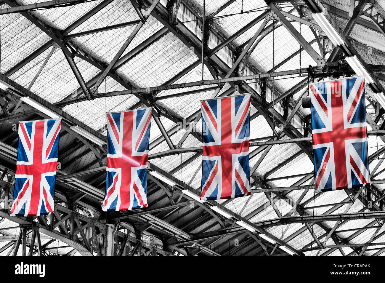 Union Jack appeso bandiere a Londra la stazione ferroviaria di Victoria. Monocromatico con spot bandiere colorate Foto Stock