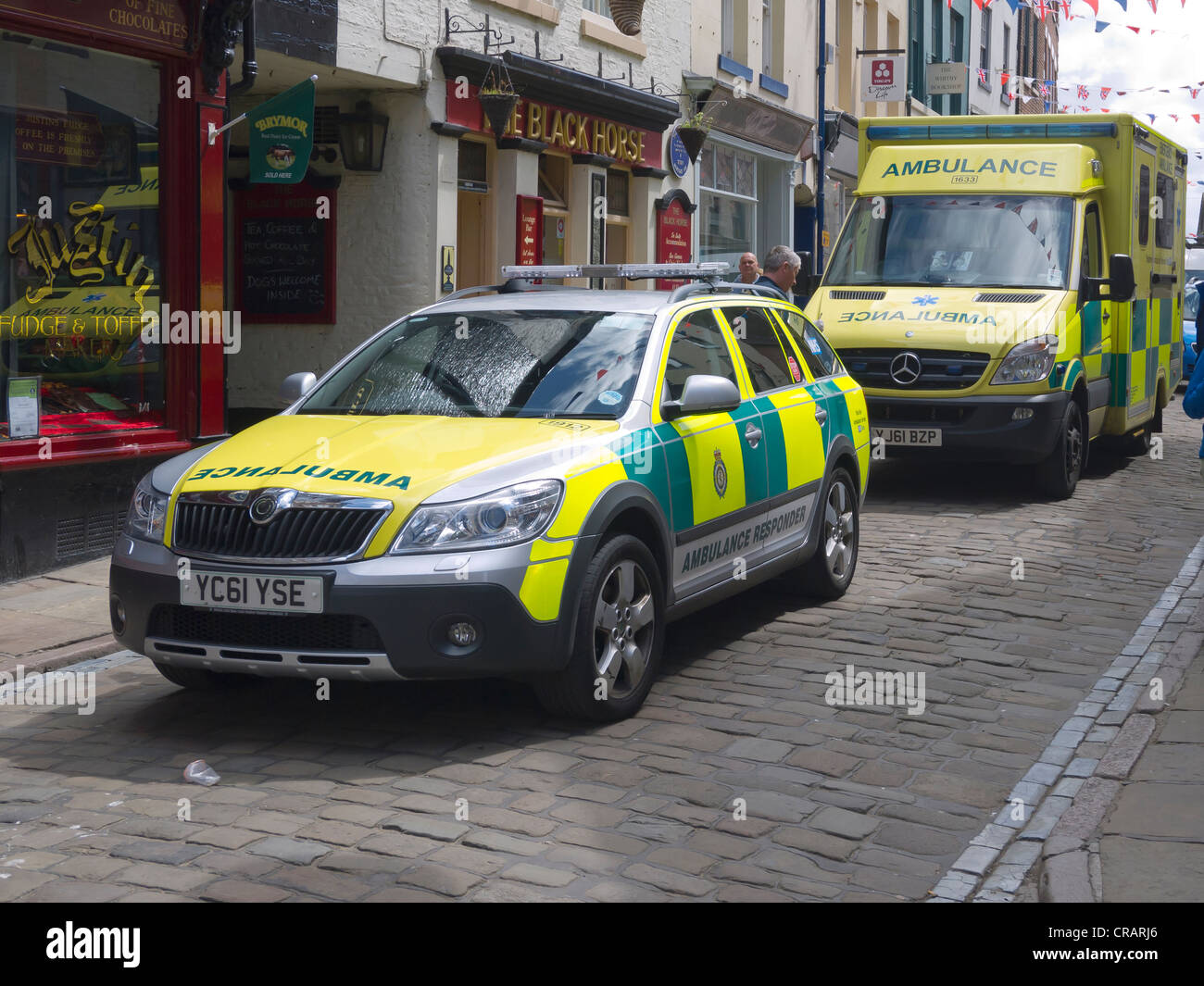 Due ambulanze chiamato in caso di emergenza in una strada stretta a Whitby bloccando l'accesso per tutti gli altri tipi di traffico Foto Stock