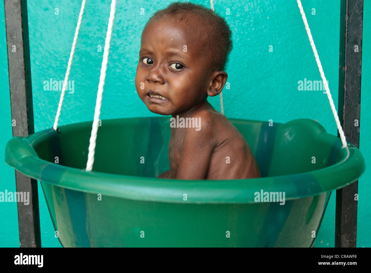 Garsiline Koko, 3, chi soffre di malnutrizione, viene pesato a Pipeline health center di Monrovia, Montserrado county Foto Stock