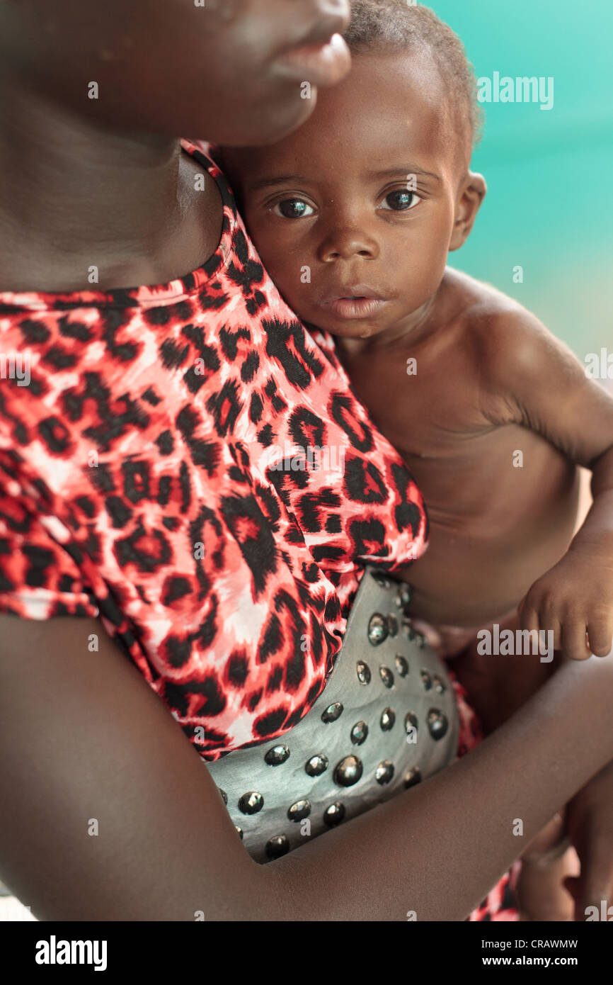 Chacklie Soman, 17, mantiene il suo figlio Leo Karsor, 8 mesi, chi è affamato, durante la crescita il monitoraggio Foto Stock