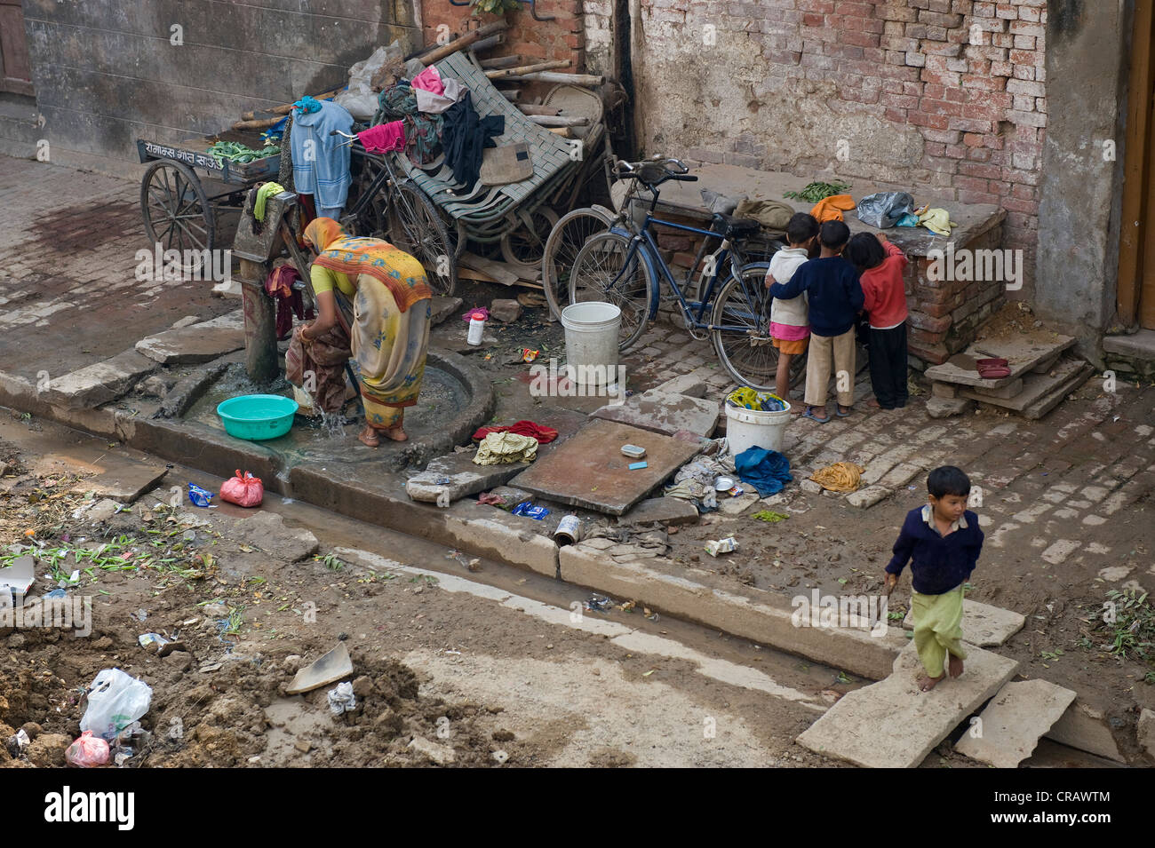 Lavaggio di donne e bambini che giocano, vecchia di Varanasi, Uttar Pradesh, India, Asia Foto Stock
