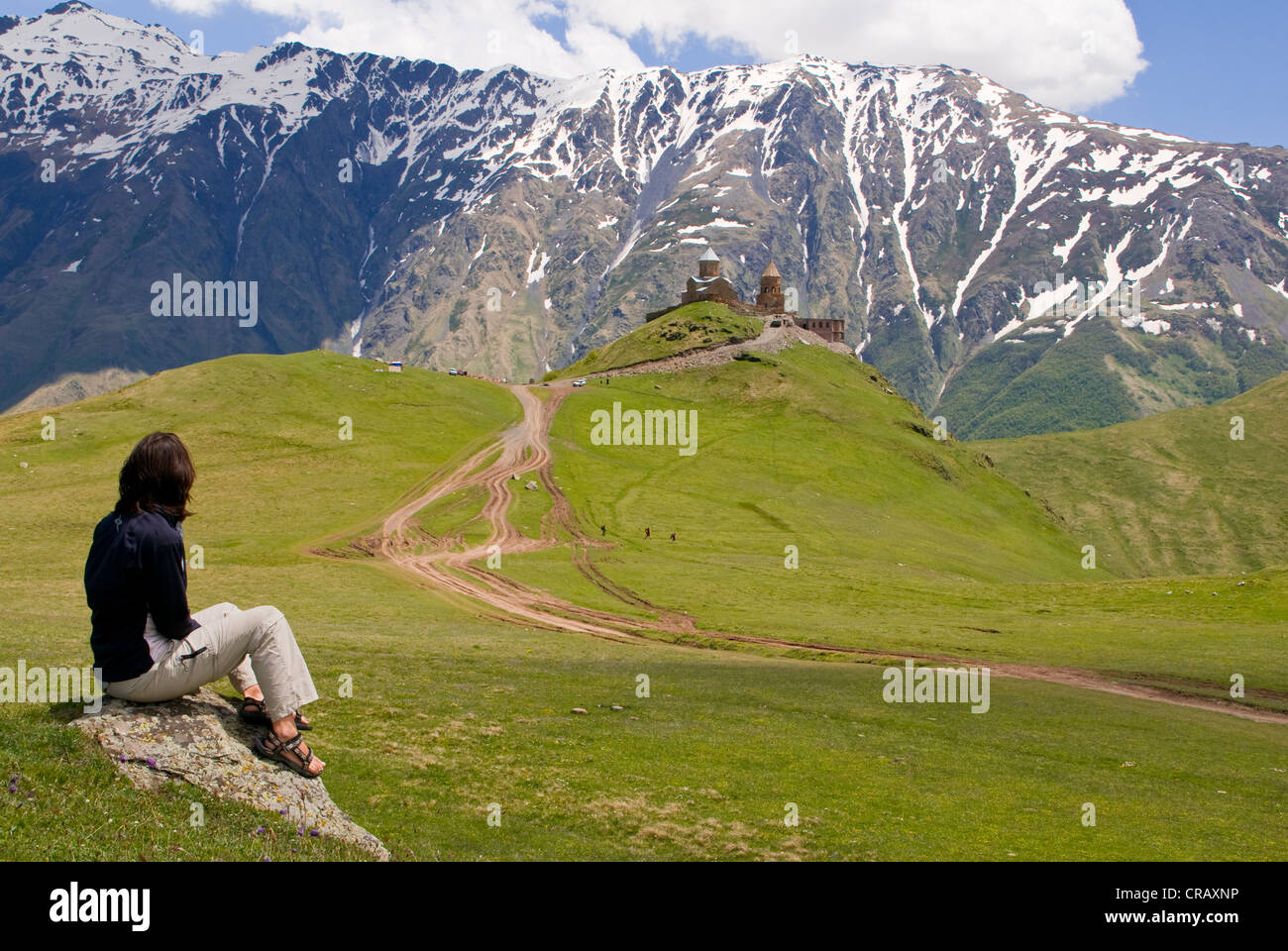 Giovane donna godendo della vista sul paesaggio montano intorno a Kazbegi, Stepantsminda, Georgia, Medio Oriente Foto Stock