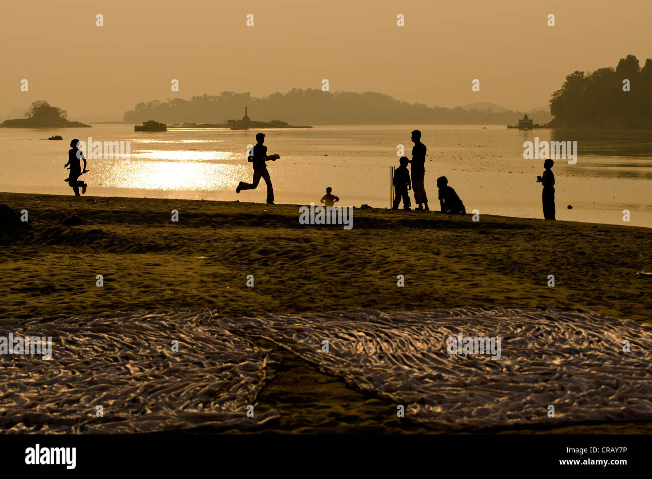 Gli adolescenti a giocare a cricket, il gioco nazionale dell'India, sulla banca del fiume Brahmaputra, Guwahati, Assam, India, Asia Foto Stock