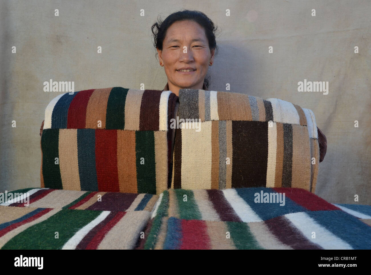 Yak tibetani tessitore di lana con orgoglio presenta la sua mercanzia,  colorata lana di yak mosaico, yak coperte, copriletti, Tibet, Cina Foto  stock - Alamy
