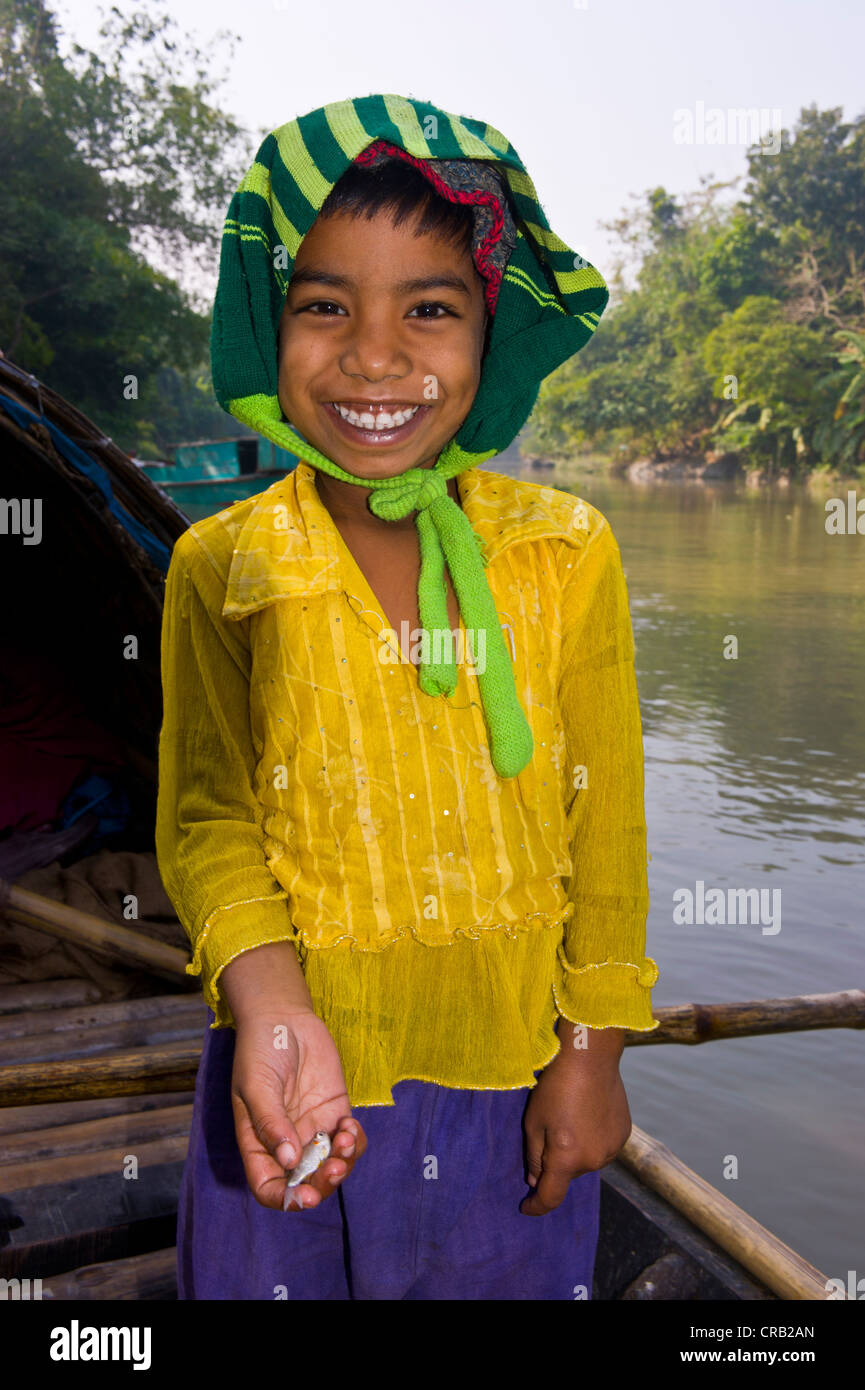 Gentile ragazza con un piccolo pesce in mano, Bangladesh Asia Foto Stock